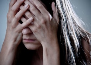 Sad person holding face with hands